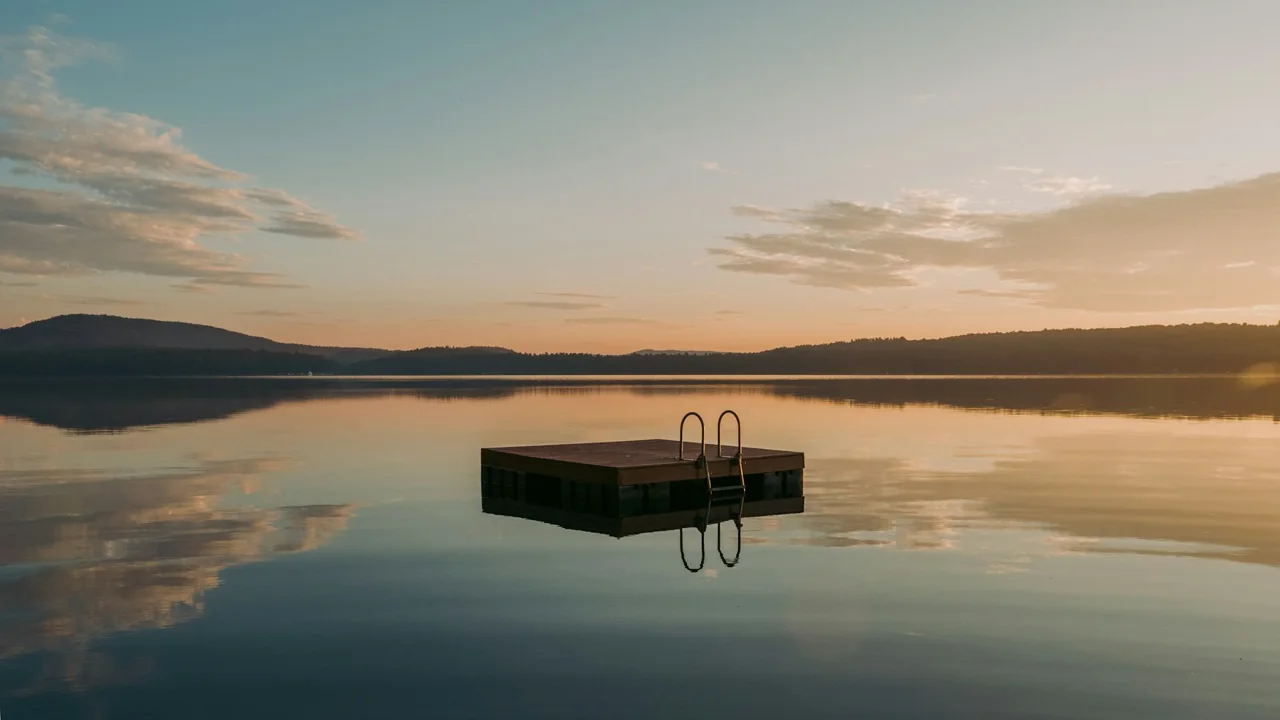 A floating platform on calm Panther Pond at sunrise in Maine
